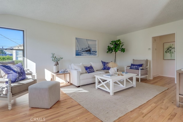 living room featuring light wood-style floors and a textured ceiling