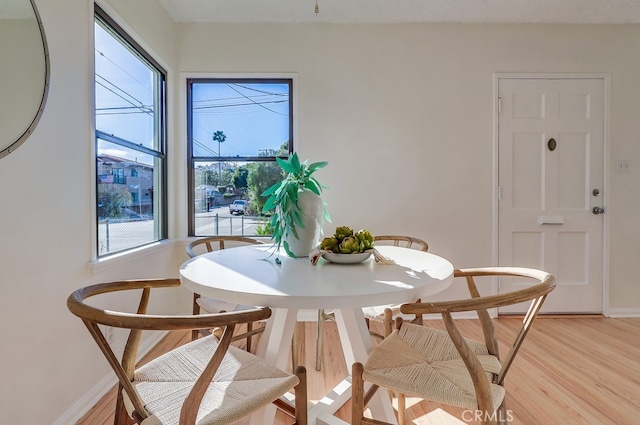 dining area featuring light wood finished floors and baseboards