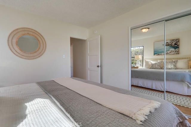 bedroom featuring a closet, a textured ceiling, and wood finished floors