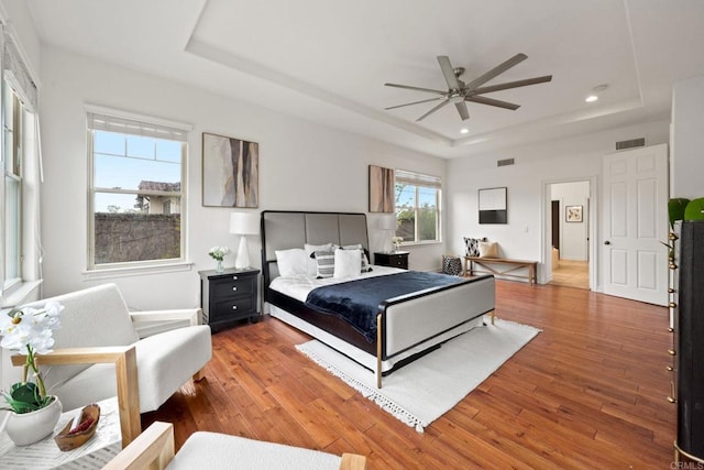 bedroom featuring recessed lighting, a raised ceiling, visible vents, and hardwood / wood-style flooring