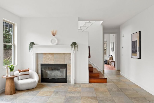 unfurnished living room featuring stairs, baseboards, and a fireplace