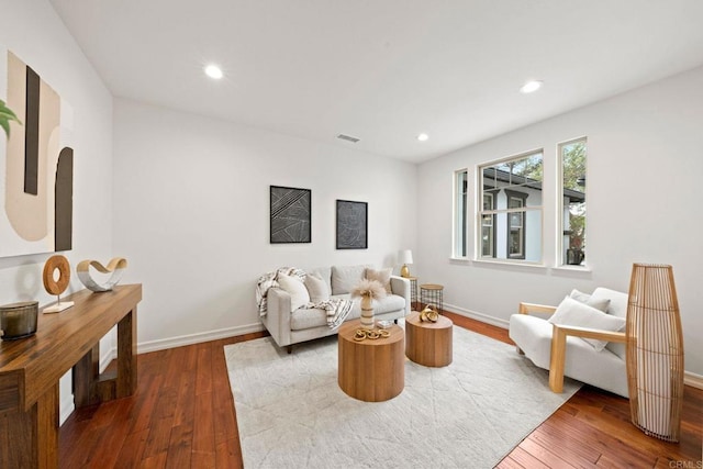 living area with recessed lighting, wood-type flooring, visible vents, and baseboards