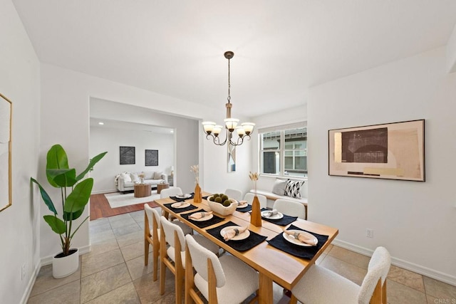 dining area featuring baseboards and a notable chandelier