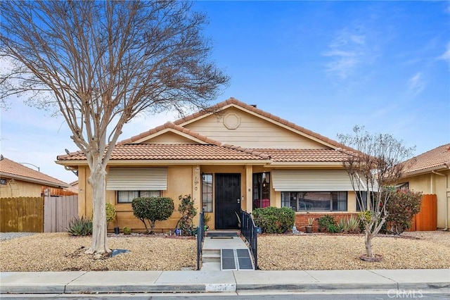 single story home with a tile roof, fence, and stucco siding