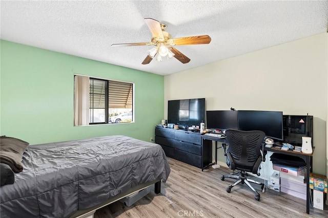 bedroom featuring a textured ceiling, wood finished floors, and a ceiling fan