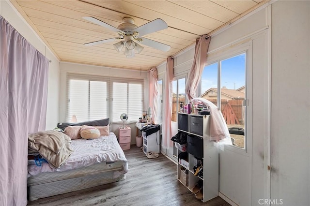 bedroom featuring ceiling fan, wooden ceiling, wood finished floors, and crown molding