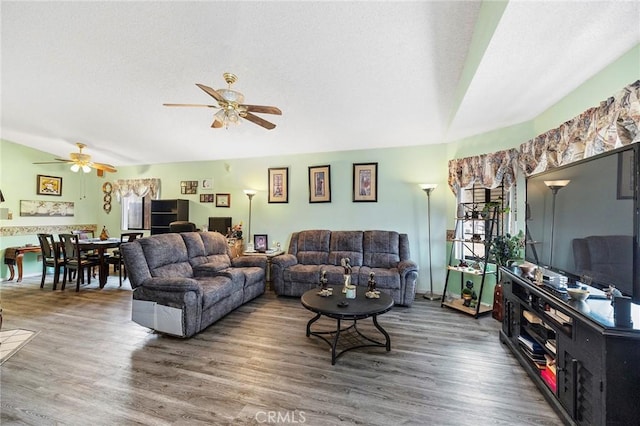 living room featuring a textured ceiling, a ceiling fan, and wood finished floors