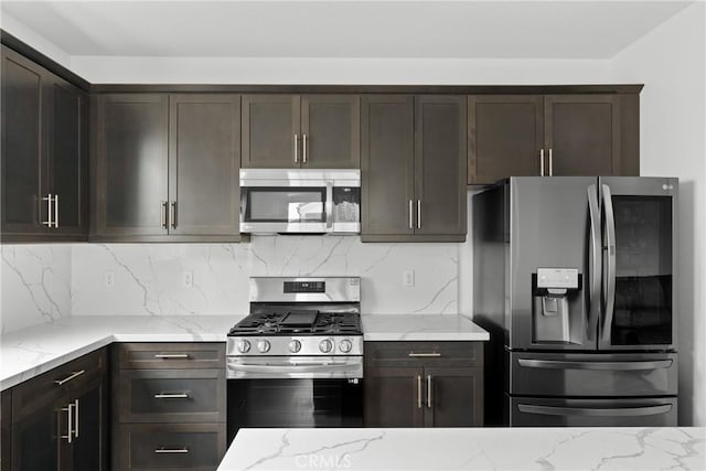 kitchen with appliances with stainless steel finishes, dark brown cabinetry, backsplash, and light stone counters