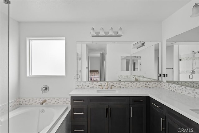 bathroom featuring ensuite bathroom, a garden tub, a sink, double vanity, and a stall shower