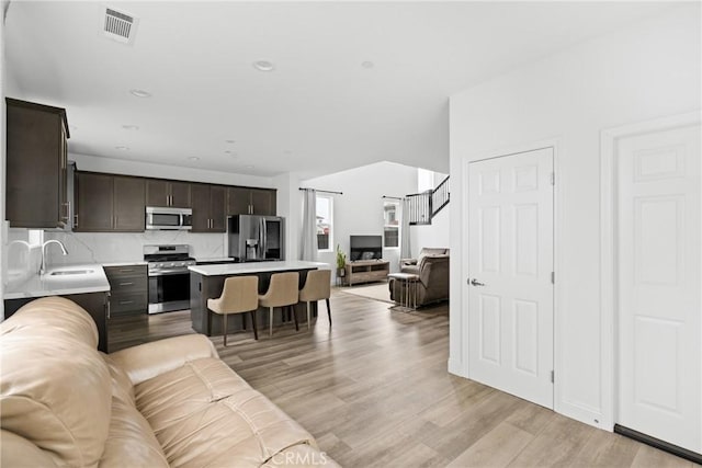 living area featuring stairway, recessed lighting, visible vents, and light wood-style flooring