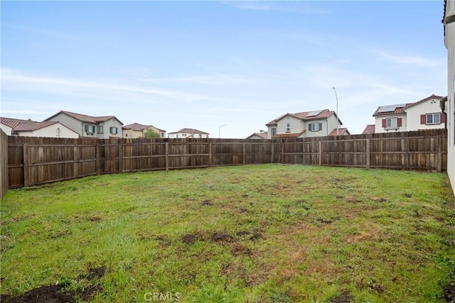 view of yard with a residential view and a fenced backyard