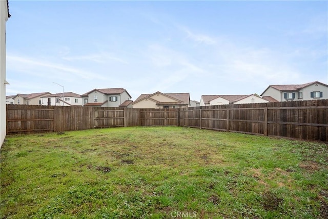 view of yard with a fenced backyard and a residential view