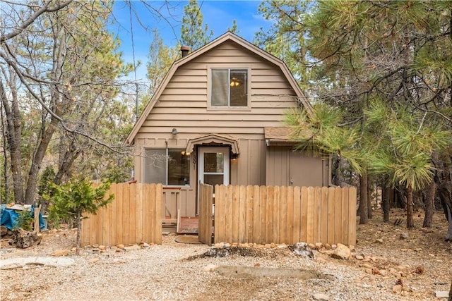 dutch colonial with fence and a gambrel roof