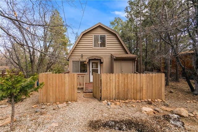 colonial inspired home with fence and a gambrel roof