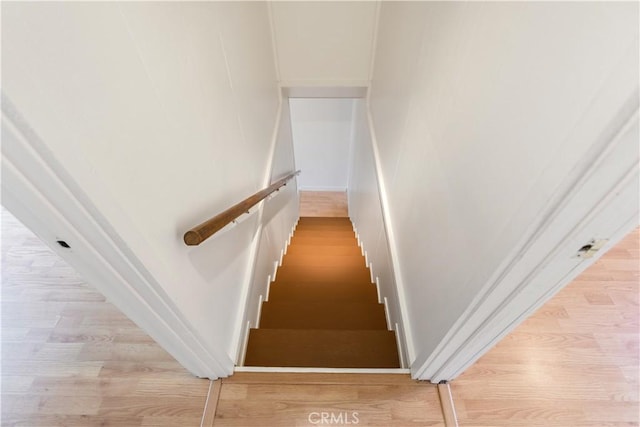 stairway featuring baseboards and wood finished floors