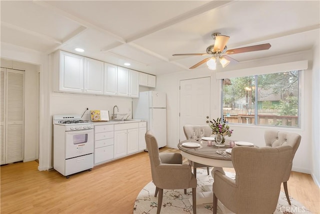 kitchen featuring white appliances, a sink, light wood-style flooring, and white cabinetry