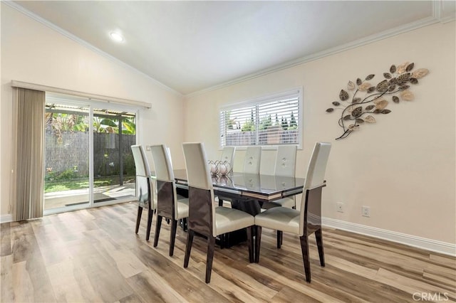 dining area featuring vaulted ceiling, ornamental molding, wood finished floors, and baseboards