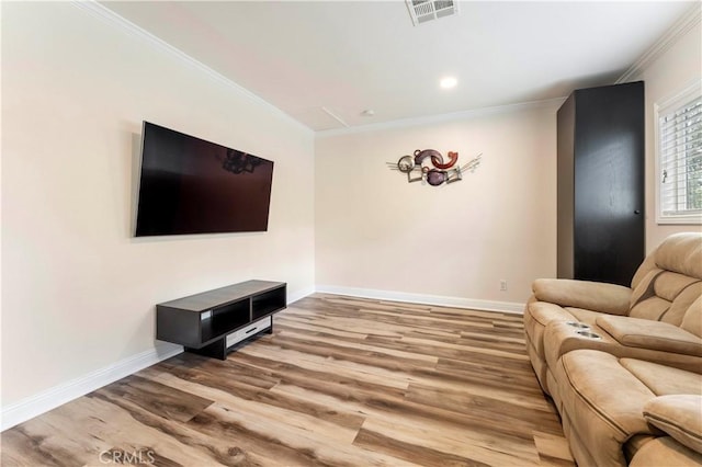 living area with visible vents, crown molding, and wood finished floors