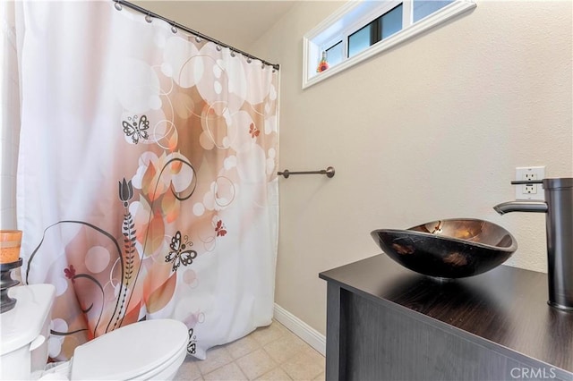 full bath featuring toilet, curtained shower, vanity, and baseboards