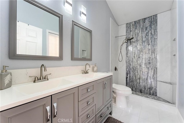 full bath featuring tiled shower, a sink, and toilet