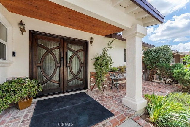 property entrance with stucco siding and french doors