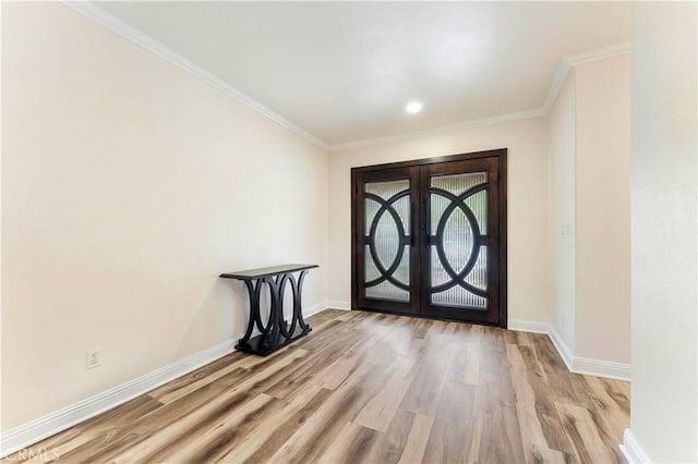 entryway with light wood-style flooring, baseboards, crown molding, and french doors