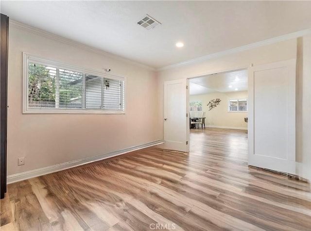 spare room with ornamental molding, visible vents, recessed lighting, light wood-style flooring, and baseboards
