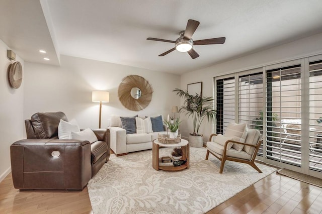 living area featuring light wood-style floors, a ceiling fan, and recessed lighting