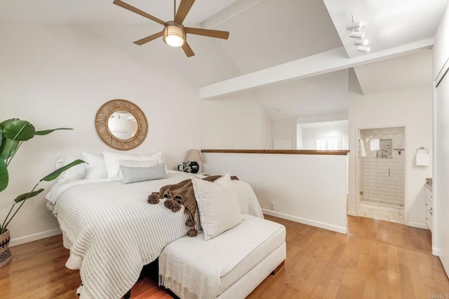 bedroom with connected bathroom, vaulted ceiling with beams, baseboards, and wood finished floors