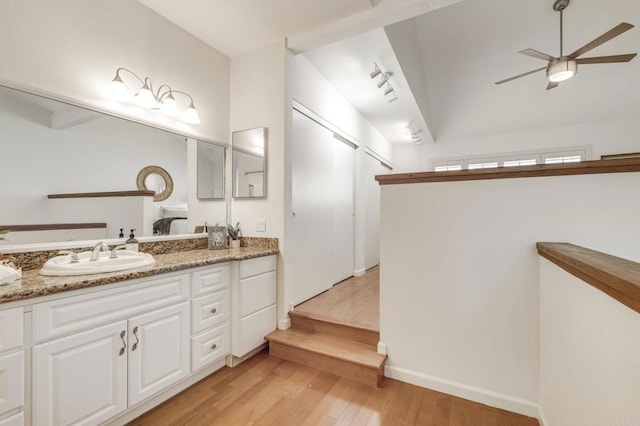 full bath with ceiling fan, vaulted ceiling, wood finished floors, and vanity