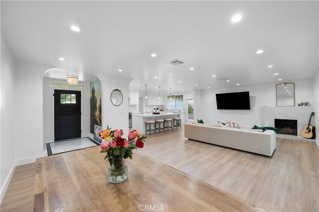 interior space featuring light wood finished floors, a premium fireplace, visible vents, and recessed lighting