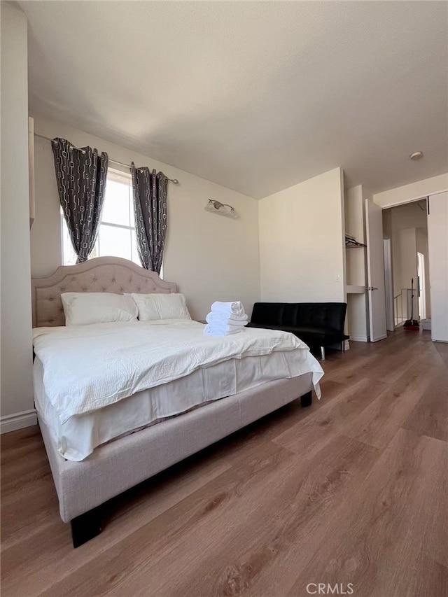 bedroom with wood finished floors and baseboards