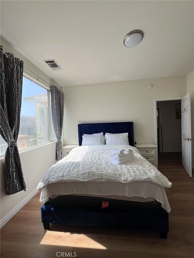 bedroom with visible vents and wood finished floors