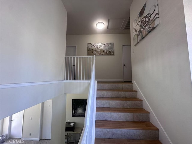 stairway with baseboards and wood finished floors