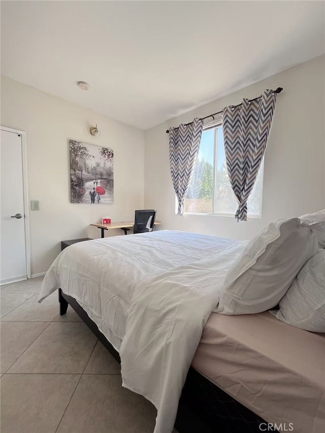 bedroom featuring baseboards and light tile patterned floors