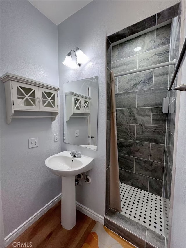 full bath with wood finished floors, a shower stall, and baseboards