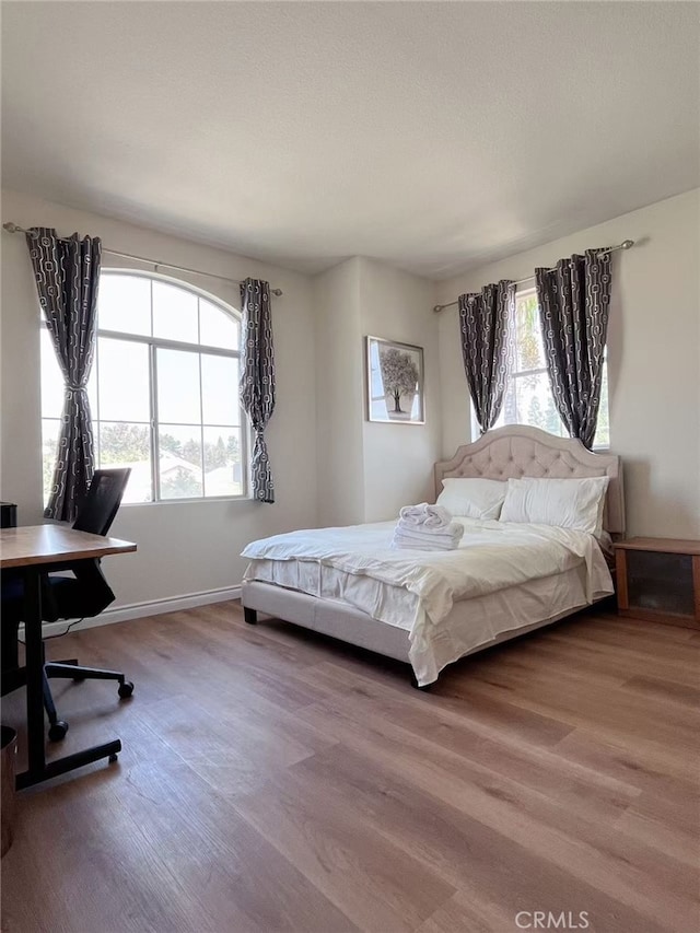 bedroom featuring wood finished floors and baseboards