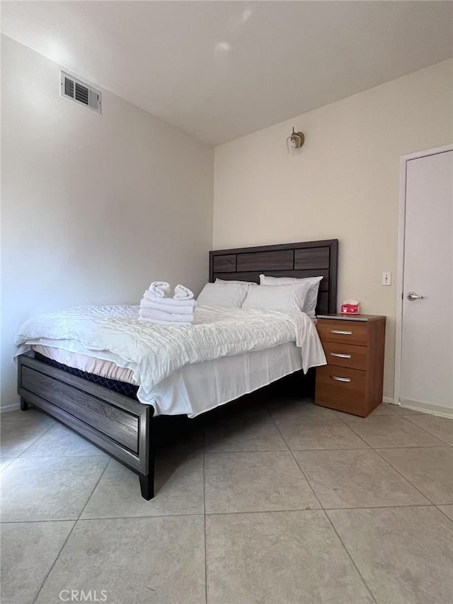 bedroom featuring visible vents, baseboards, and light tile patterned floors