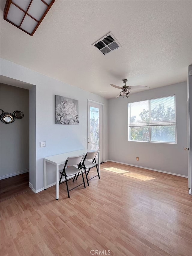 interior space featuring a ceiling fan, plenty of natural light, visible vents, and light wood-style floors