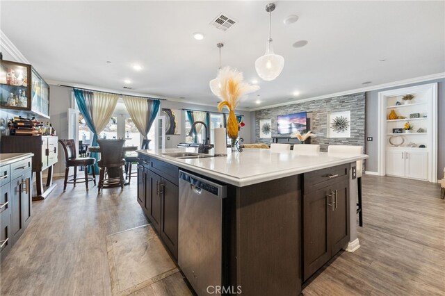 20900 Center St, Riverside, CA 92507 - kitchen featuring dishwasher, ornamental molding, wood finished floors, light countertops, and a center island with sink