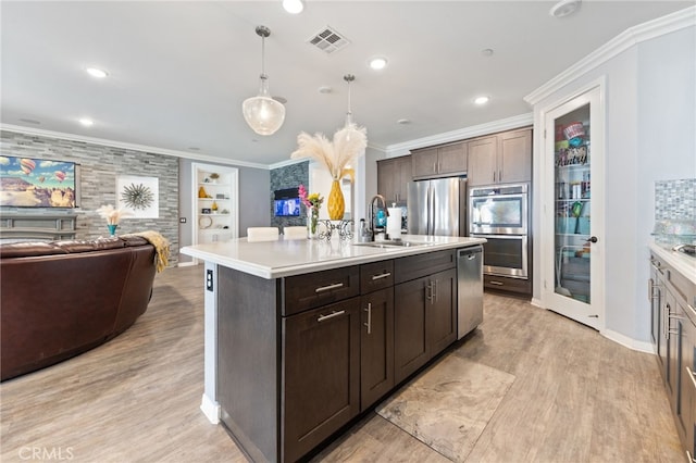 20900 Center St, Riverside, CA 92507 - kitchen with appliances with stainless steel finishes, open floor plan, crown molding, light wood-style floors, and light countertops