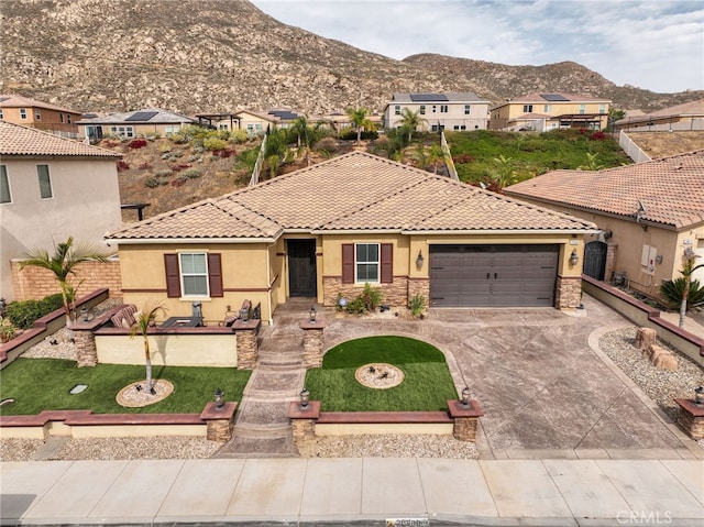 20900 Center St, Riverside, CA 92507 - view of front facade with stucco siding, a mountain view, stone siding, driveway, and an attached garage