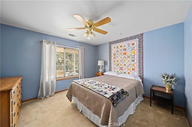 bedroom with a ceiling fan, visible vents, light carpet, and baseboards