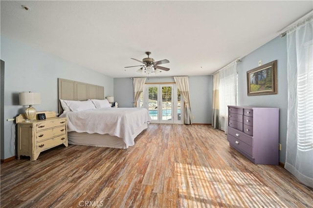 bedroom featuring access to exterior, ceiling fan, baseboards, and wood finished floors