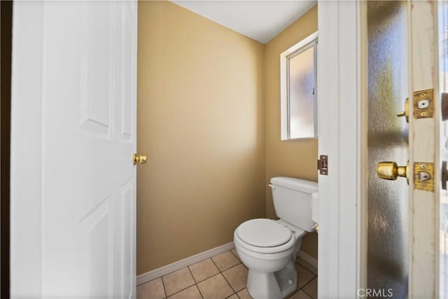 bathroom with toilet, tile patterned flooring, and baseboards