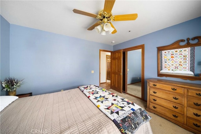 bedroom with a ceiling fan, a closet, and light colored carpet