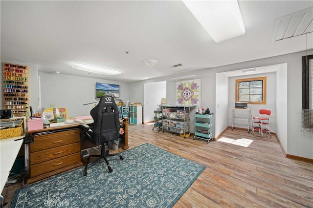 home office with light wood-style floors, visible vents, and baseboards