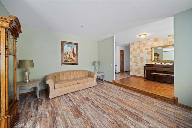 living area with baseboards and wood finished floors