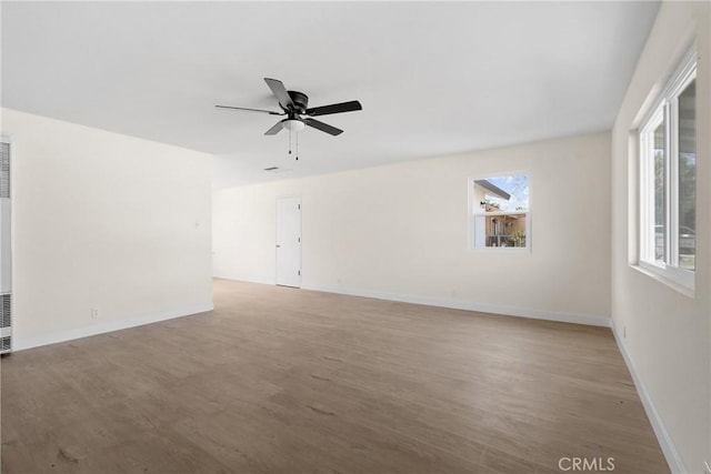 unfurnished room featuring ceiling fan, light wood-style flooring, and baseboards