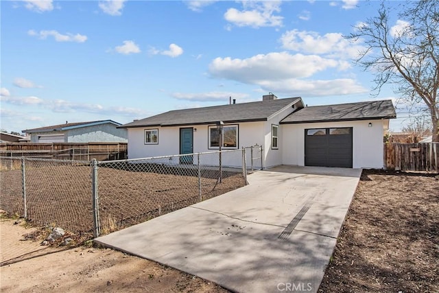 ranch-style home with driveway, an attached garage, fence private yard, and stucco siding